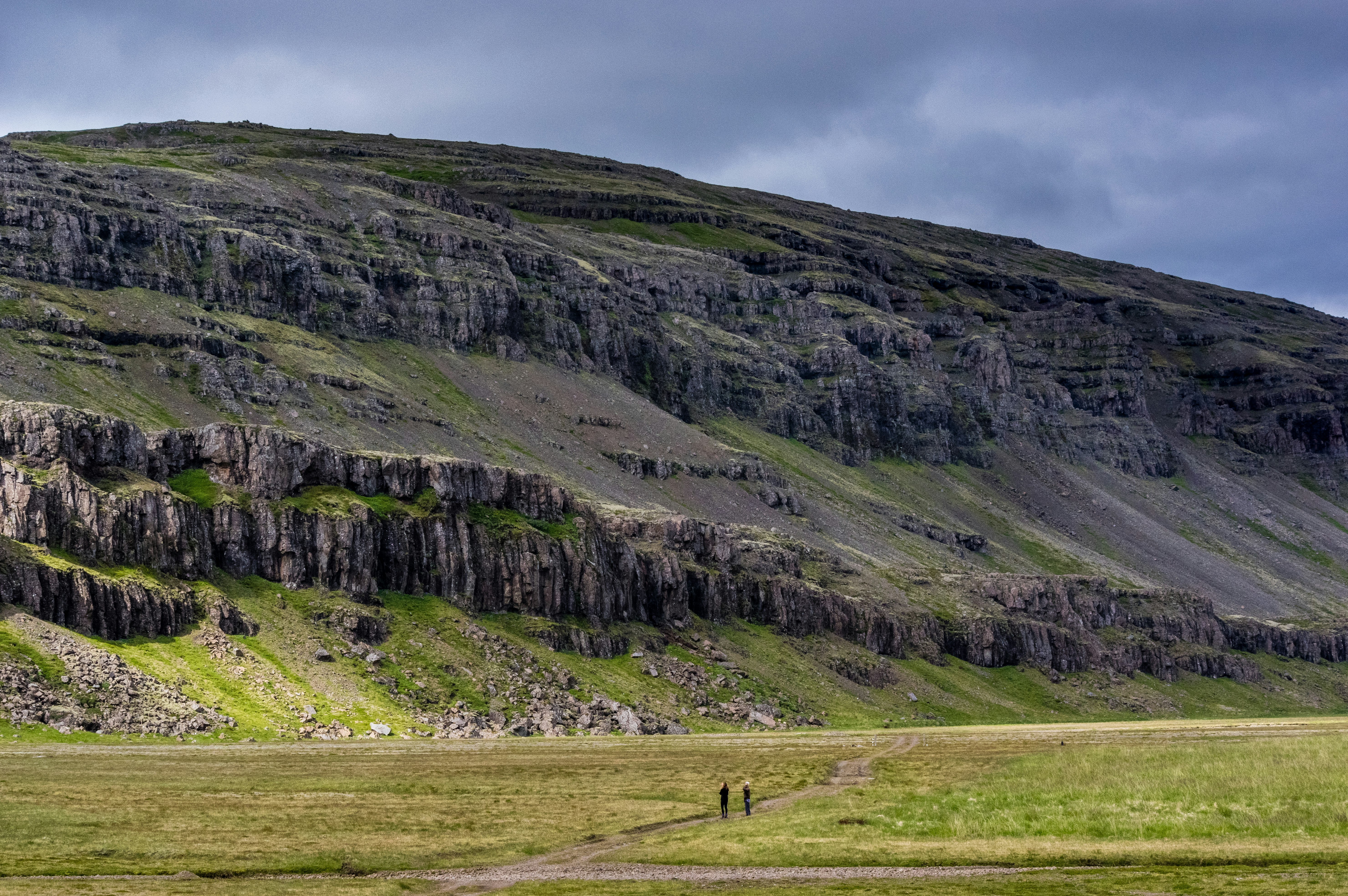 two people standing on field near cliff